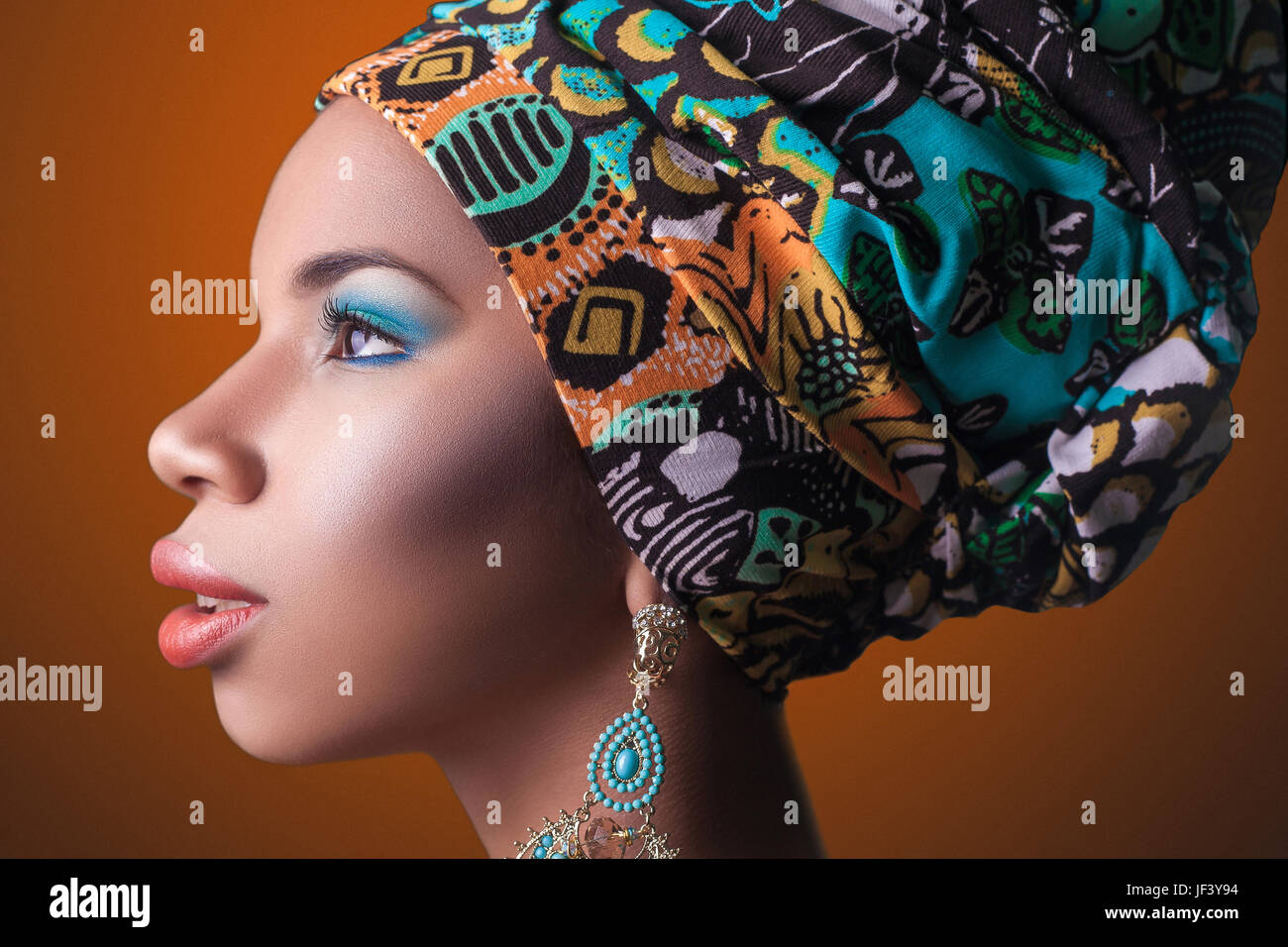 young beautiful fashion model with traditional african style with scarf, earrings and makeup on orange background Stock Photo - Alamy young beautiful fashion model with traditional african style with scarf, earrings and makeup on orange background Stock Photo - Alamy