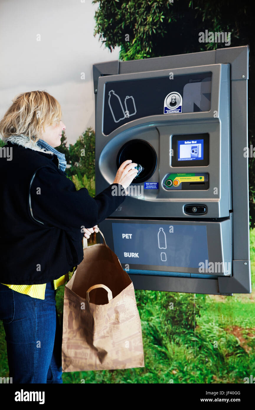 Hand putting bottle in recycling bottle machine Stock Photo Alamy