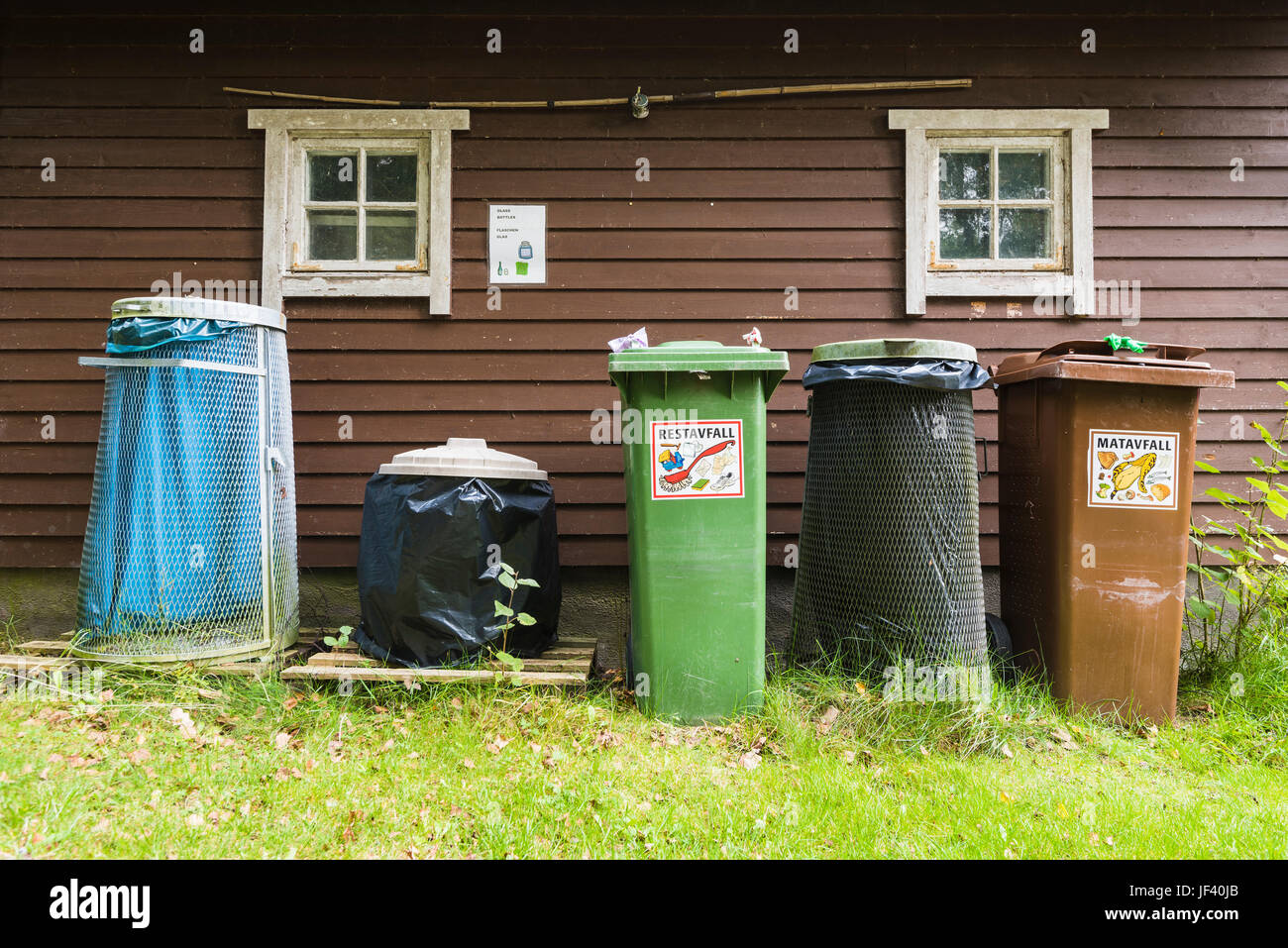 Bins in front of wooden house Stock Photo Alamy