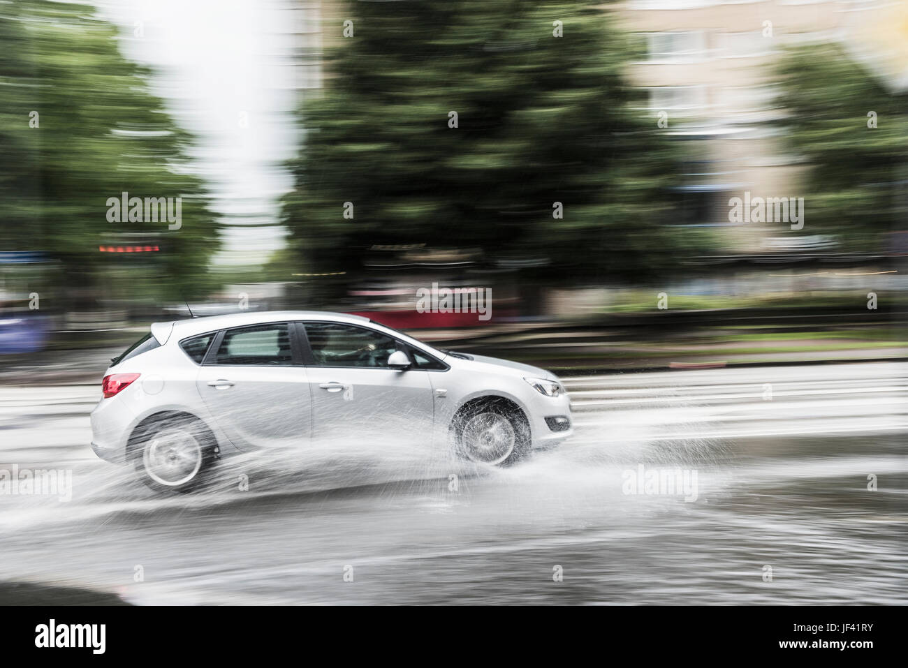 Car splashing water on road Stock Photo