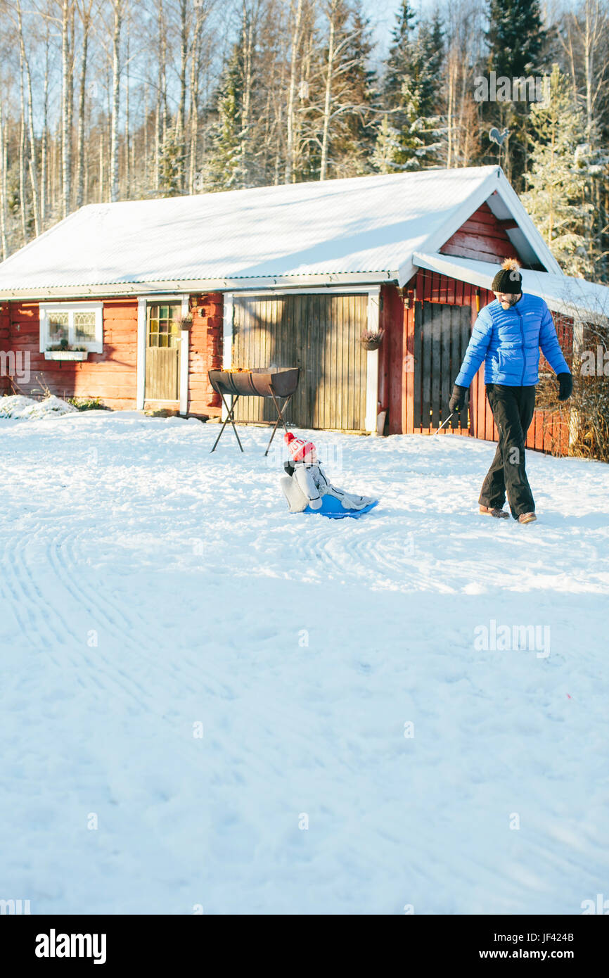 Father pulling baby on sledge Stock Photo Alamy