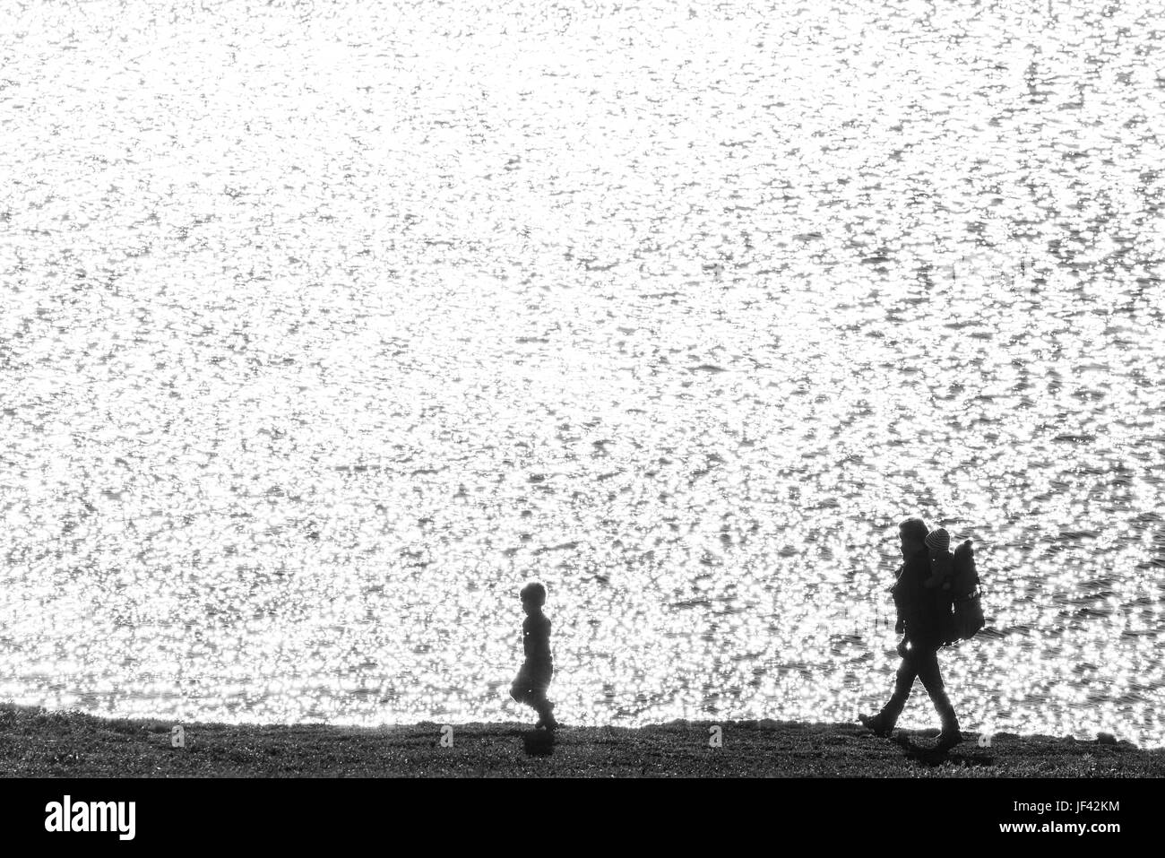 Silhouettes of father with children at sea Stock Photo