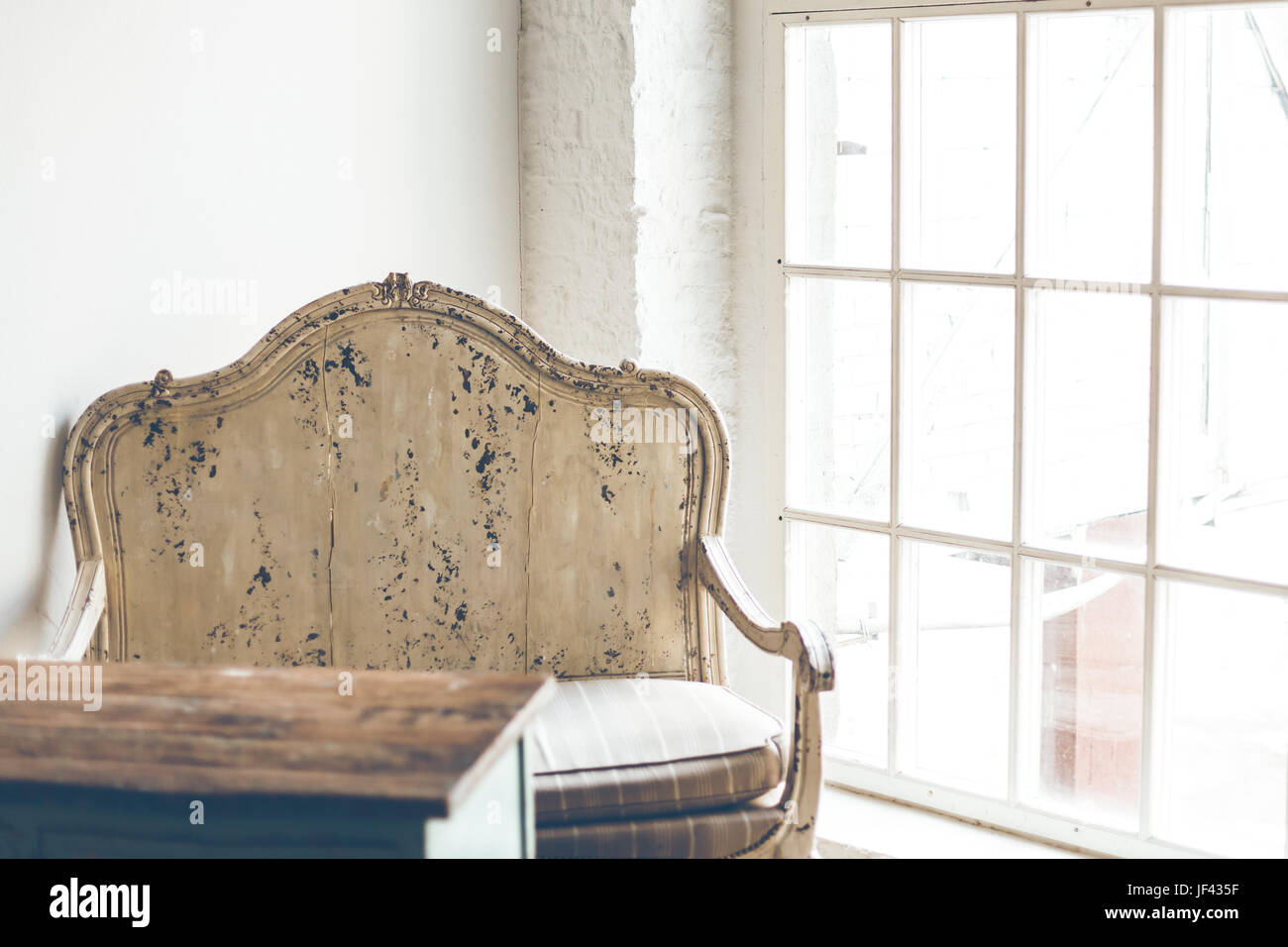 Vintage armchair and a wooden table in a room with white walls and a ...