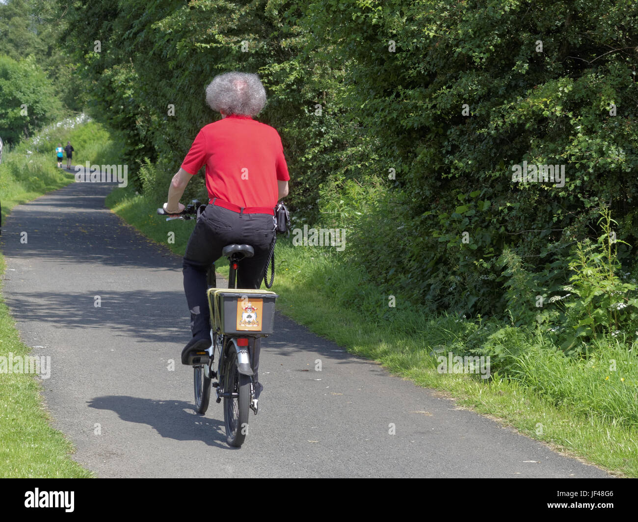 Forth and Clyde canal Glasgow Scotland cyclist on bike on the tow path cycling Scotland red shirt Glasgow coat of arms on box Stock Photo