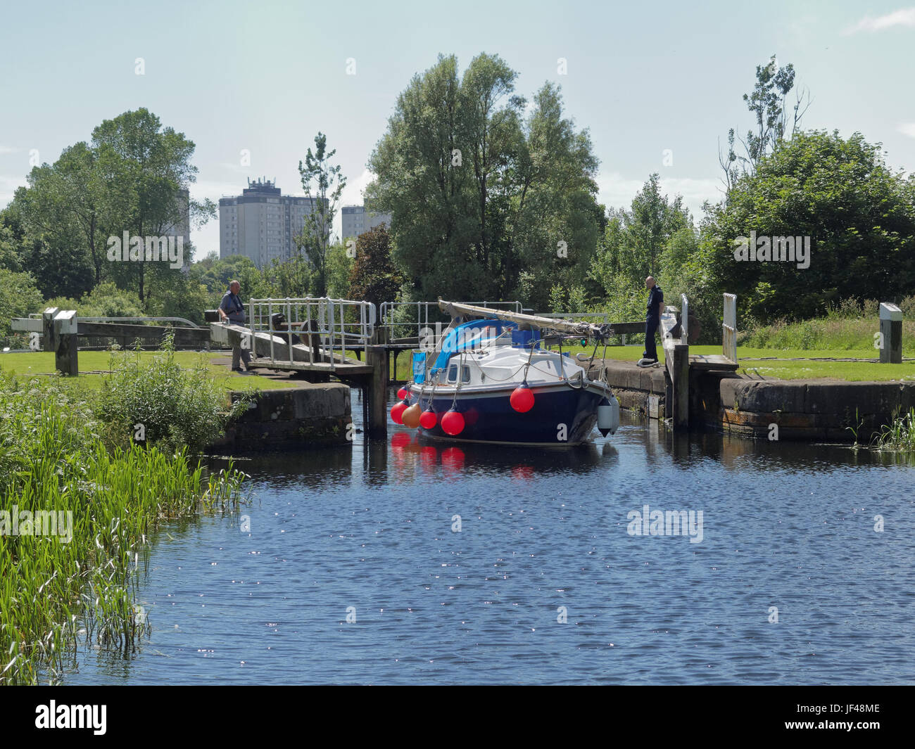 Forth and Clyde canal Glasgow Scotland yacht blue spindrift makes its way through canal its way to the river carron Stock Photo