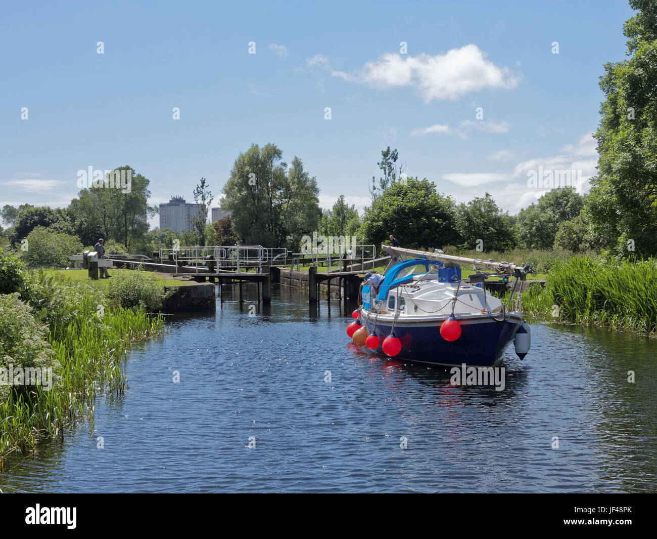 Forth and Clyde canal Glasgow Scotland yacht blue spindrift makes its way through canal its way to the river carron Stock Photo