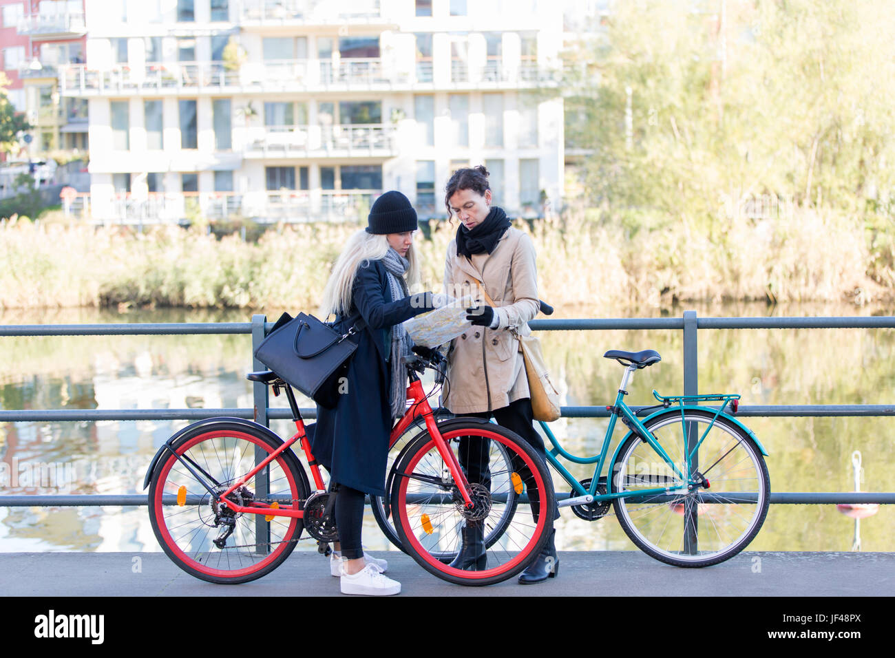 Women with bicycles looking at map Stock Photo