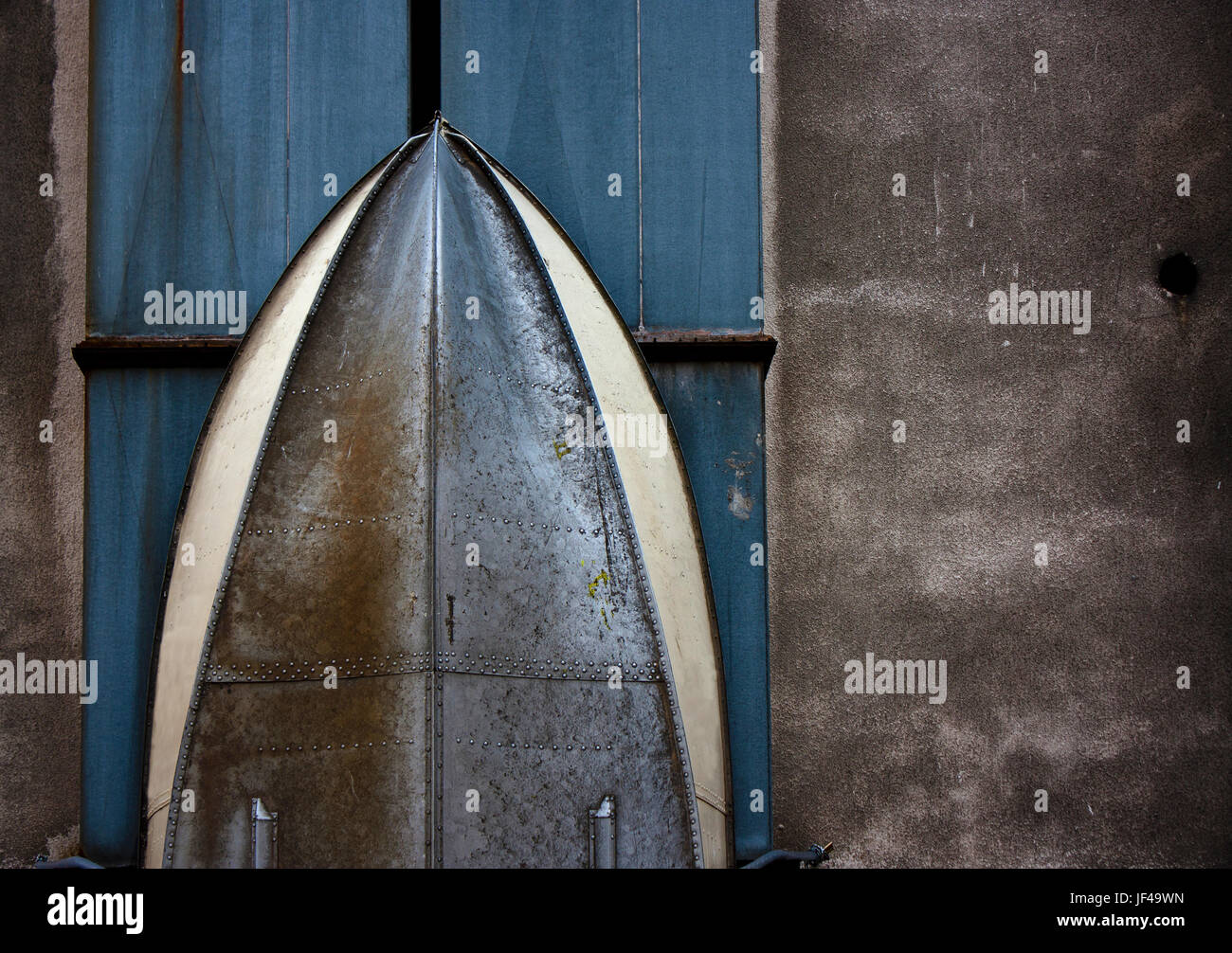 Metal hull with rivets of a boat stored vertically against the wall , detail abstract Stock Photo
