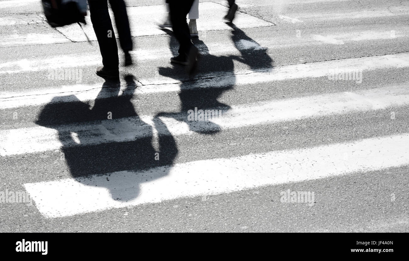 Shadow and silhouette of family with children at zebra crossing Stock Photo
