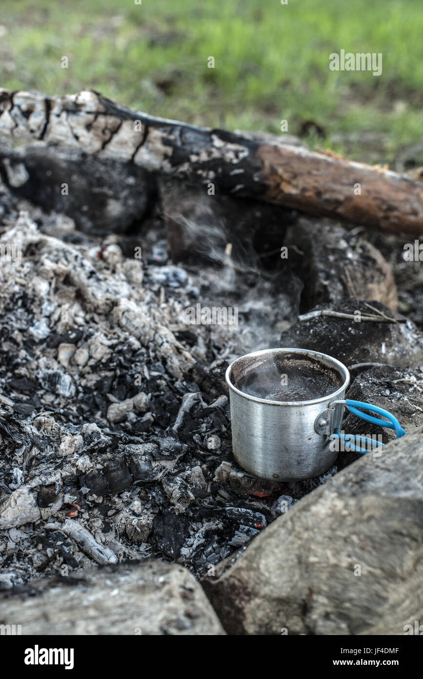 Campfire, old coffee pot on the fire hires stock photography and