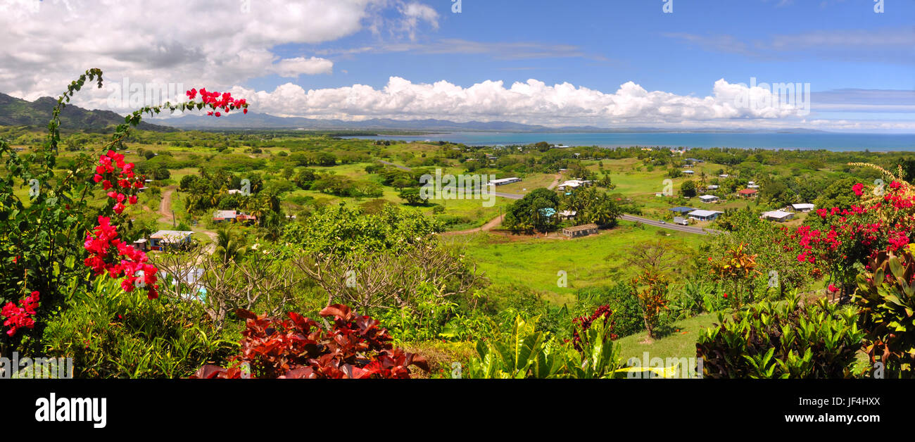 Panorama of the Fijian west coast. In the foreground Hibiscus - the Fijian national symbolic flower. In the background Nadi and Denarau Island. Stock Photo