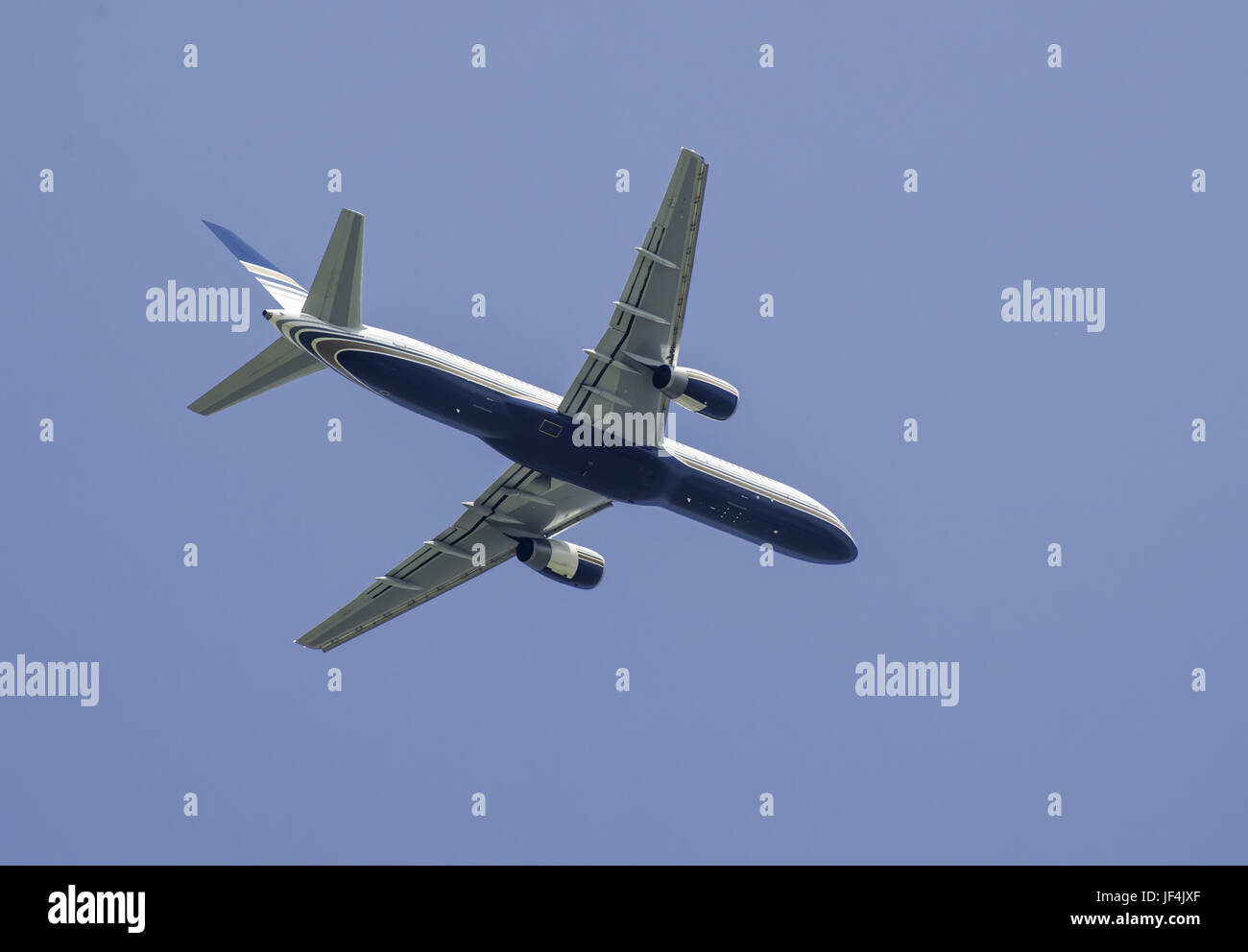 Flying plane on blue sky background Stock Photo - Alamy
