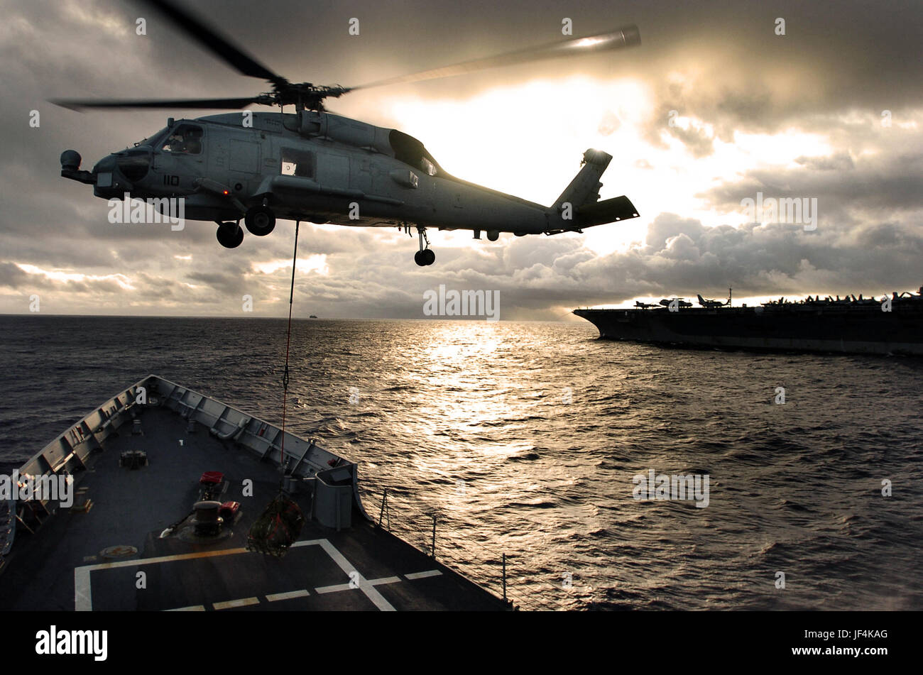 A SH60 Seahawk helicopter picks up cargo from the flight deck of the