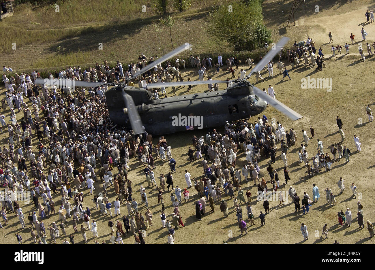 051017-F-9085B-005  Pakistani earthquake victims crowd around a U.S. Army CH-47 Chinook helicopter delivering disaster relief supplies to the earthquake devastated area surrounding the town of Oghi, Pakistan, on Oct. 17, 2005.  The Department of Defense is participating in the multinational effort to provide humanitarian assistance and support to Pakistan and parts of India and Afghanistan following a devastating earthquake.  DoD photo by Tech. Sgt. Mike Buytas, U.S. Air Force.  (Released) Stock Photo