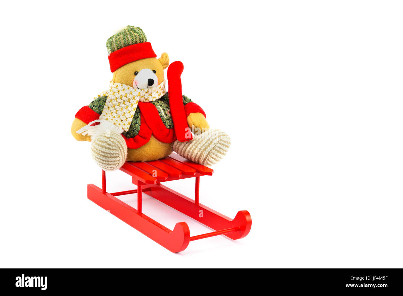 Dressed Christmas bear on red wooden sleigh Stock Photo