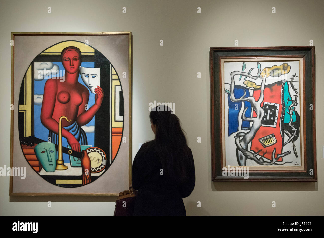 London, UK.  29 June 2017.  A woman views (L to R) 'Les Masques', 1928, by Jean Metzinger and 'Le Tapis Rouge Dans Le Paysage', 1952, by Fernand Léger during a visit to Masterpiece London, a leading art fair held in the grounds of the Royal Hospital Chelsea.  The fair brings together 150 international exhibitors presenting works from antiquity to the present day and runs 29 June to 5 July 2017. .   Credit: Stephen Chung / Alamy Live News Stock Photo