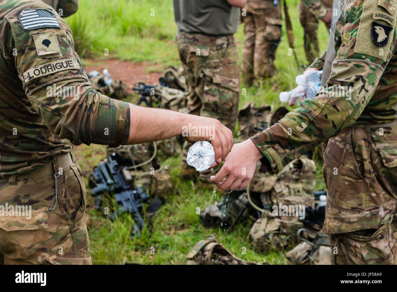 A U.S. Soldier assigned to the 1st Battalion, 506th Infantry Regiment, 1st Brigade Combat Team, 101st Airborne Division helps his ‘Battle Buddy’ clean a notional wound during United Accord 2017 at Bundase Training Camp, Bundase, Ghana, May 26, 2017. United Accord (formerly Western Accord) 2017 is an annual, combined, joint military exercise that promotes regional relationships, increases capacity, trains U.S. and Western African forces, and encourages cross training and interoperability. (U.S. Army photo by Spc. Victor Perez Vargas) Stock Photo