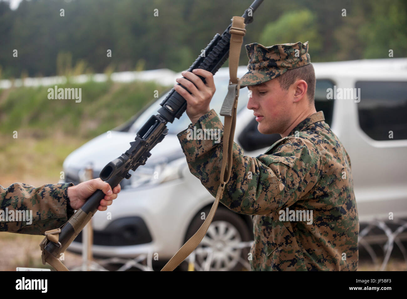 VENTSPILS, Latvia- Lance Cpl. Jeck M. Cordeiro with Combat Logistics Battalion 25, Combat Logistics Regiment 45, 4th Marine Logistics Group, distributes rifles during exercise Saber Strike 17 in Ventspils, Latvia, May 28, 2017. Exercise Saber Strike 17 is an annual combined-joint exercise conducted at variouslocations throughout the Baltic region and Poland. The combined training prepares allies and partners to respond more to regional crises and meet their own security needs by improving the security of borders and countering threats. (U.S. Marine Corps photo by Lance Cpl.  Ricardo Davila/Rel Stock Photo