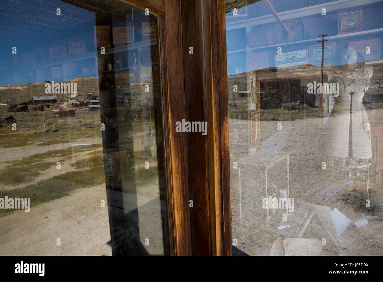 The interior of an abandoned general store and the surrounding landscape reflected in a store window. Stock Photo
