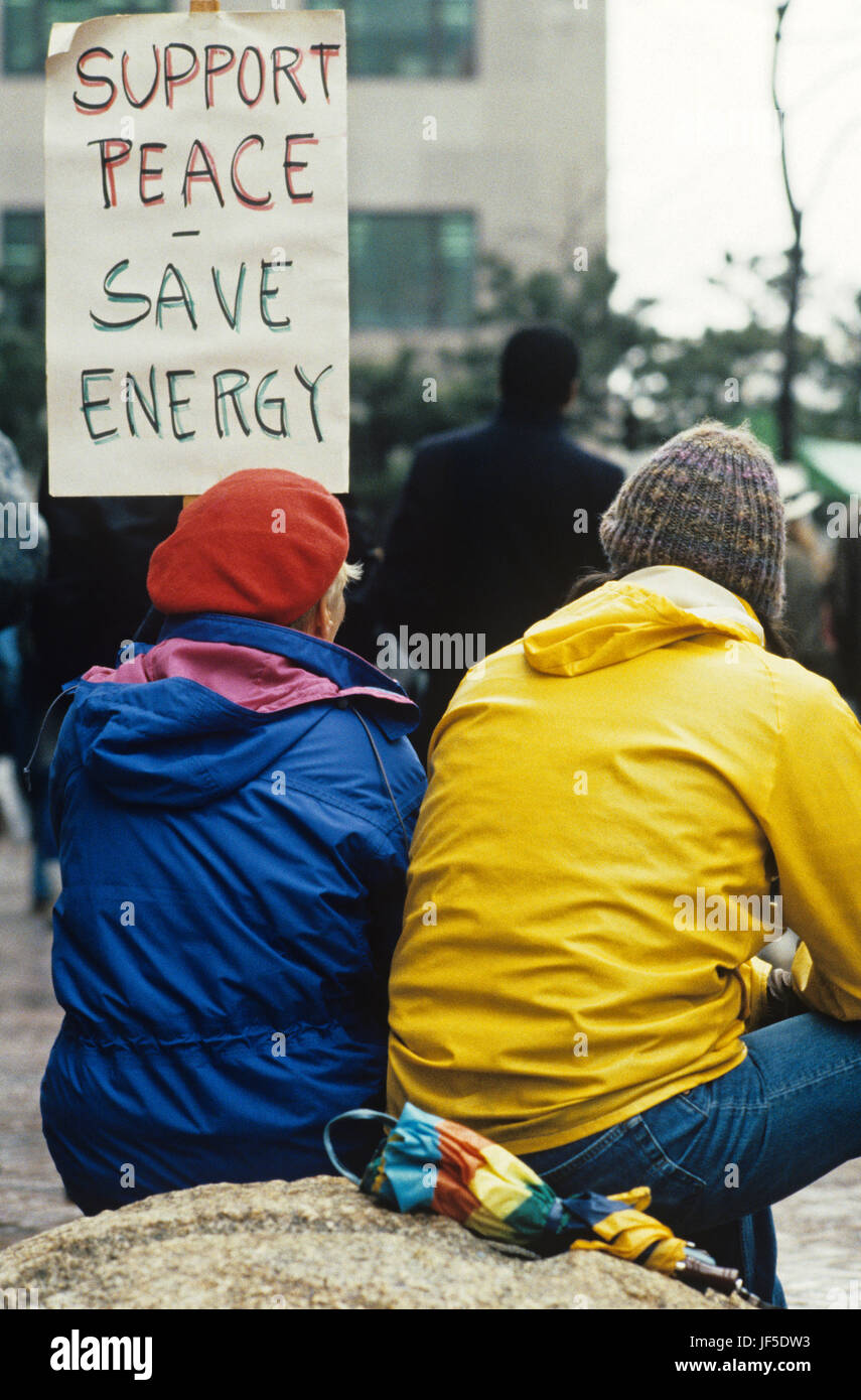 Older woman War protester at the Federal Building in downtown Seattle sitting and holding a support peace poster protesting the US involvement in Iraq Stock Photo