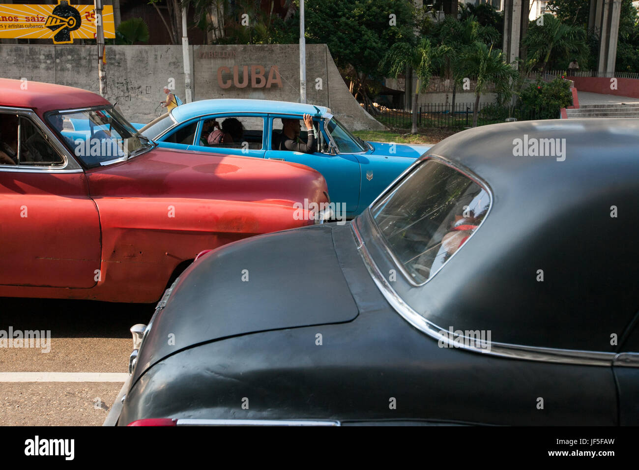 Several colorful, classic American cars line a street in downtown Havana. Stock Photo
