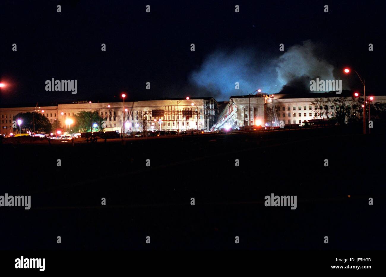 010911-D-2987S-198 Fire fighters battle stubborn fires through the night at the Pentagon on Sept. 11, 2001.  The fire was caused when a hijacked American Airlines flight slammed into the building earlier in the day.  The terrorist attack caused extensive damage to the west face of the building and followed similar attacks on the twin towers of the World Trade Center in New York City.  DoD photo by Helene C. Stikkel. Stock Photo