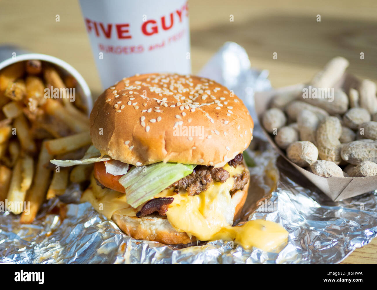 A bacon cheeseburger, French fries, and peanuts from Five Guys Burgers and Fries, an American fast casual restaurant chain. Stock Photo