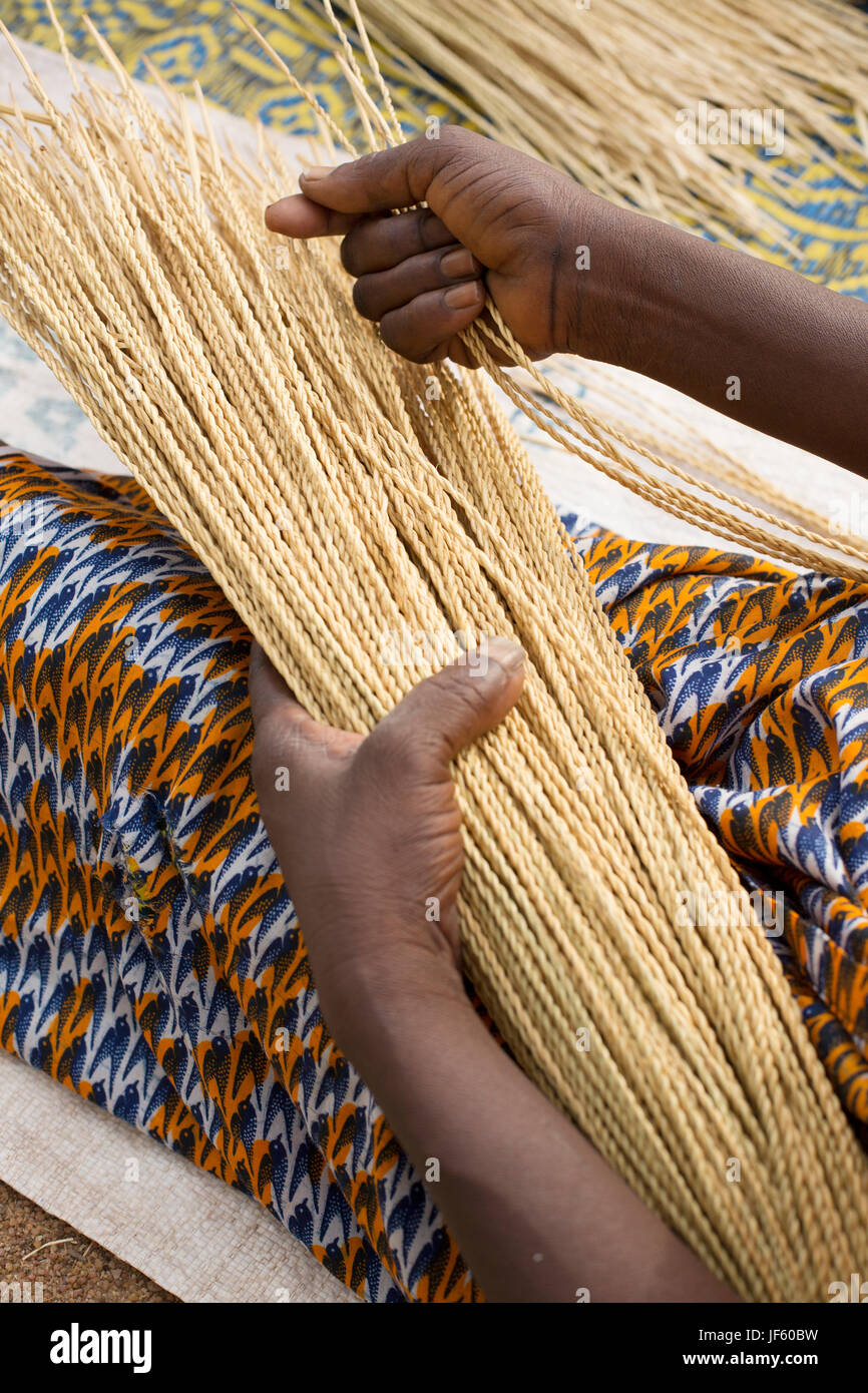 Women from a weaver’s cooperative weave traditional straw baskets together in Upper East Region, Ghana. Stock Photo