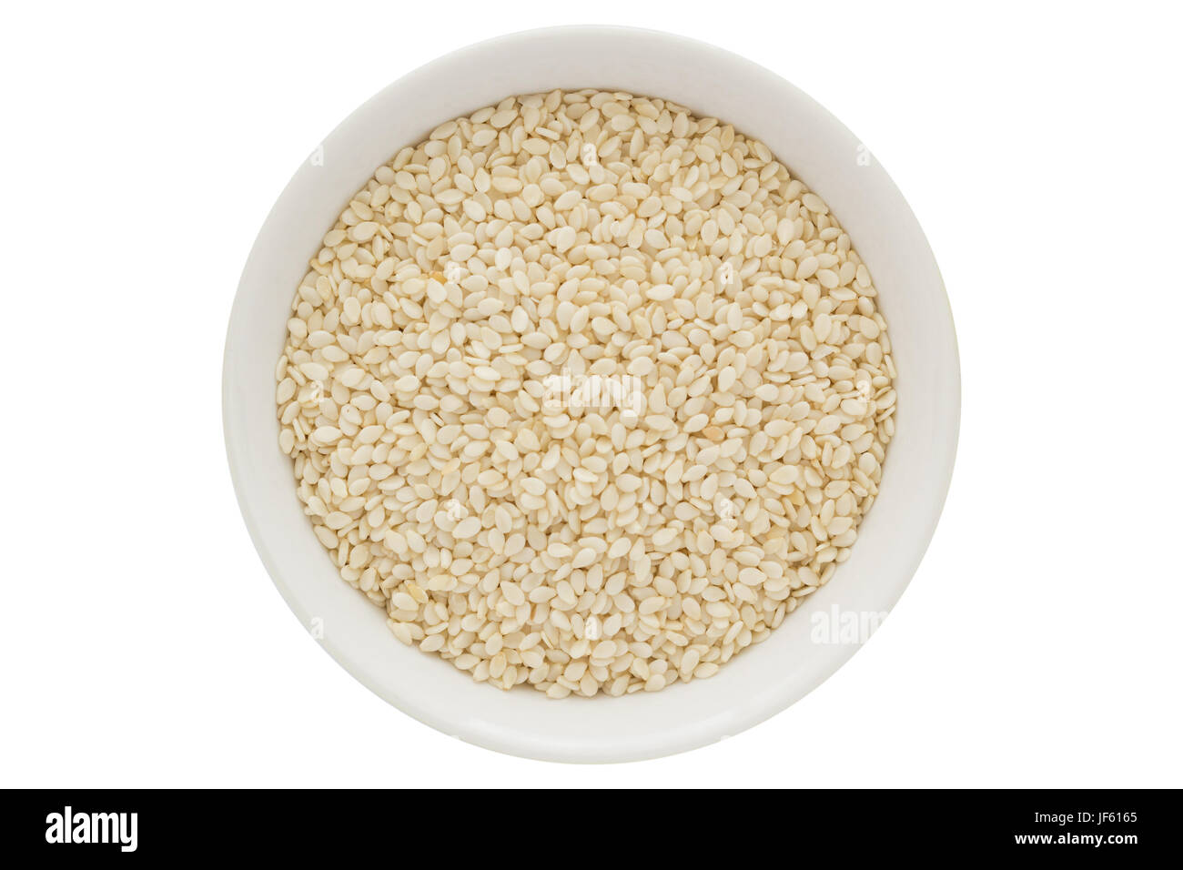 Sesame seeds in white bowl, isolated on white background Stock Photo