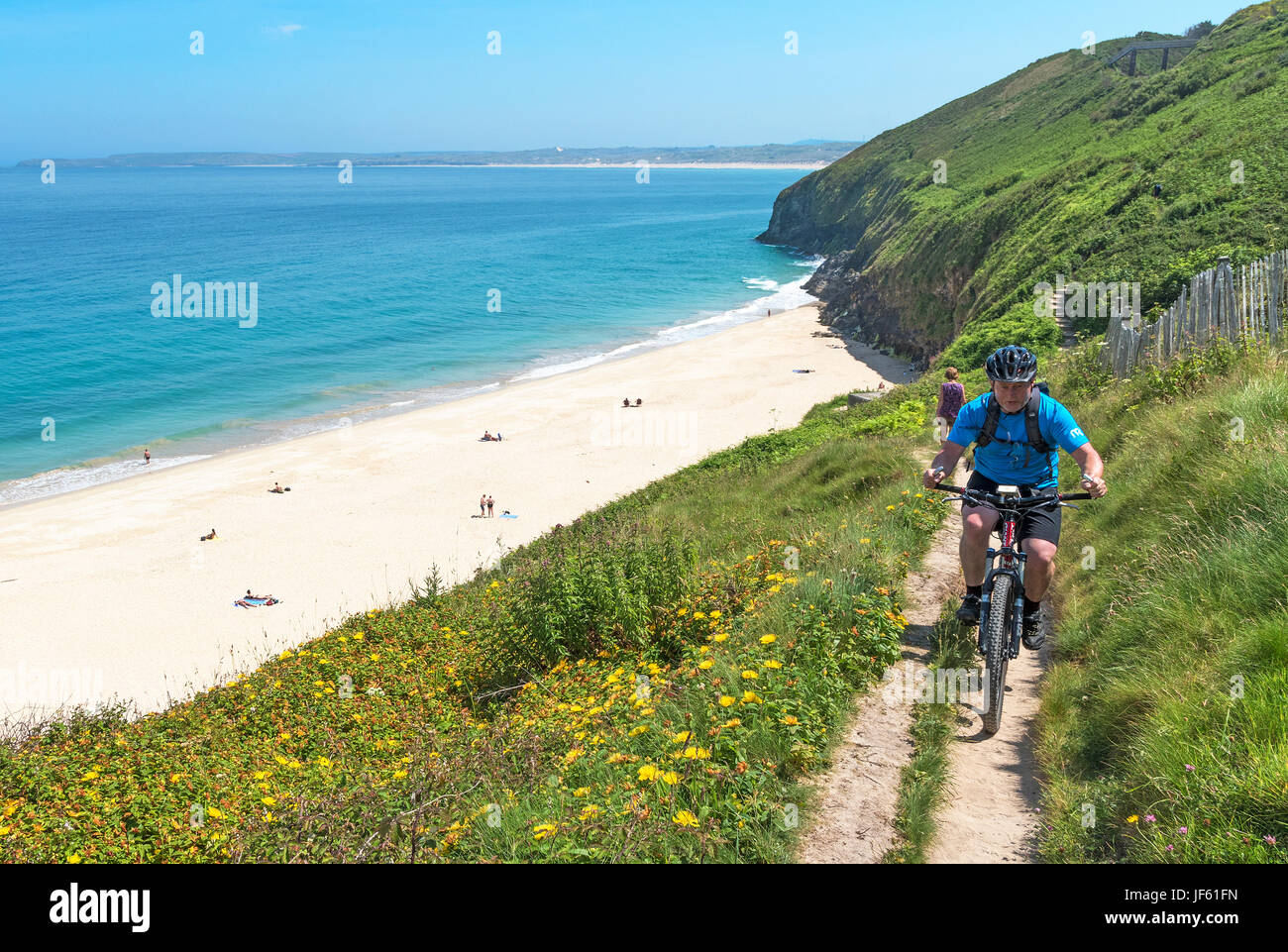 cyclist on the southwest coast path at carbis bay near st.ives in cornwall, england, britain, uk. Stock Photo