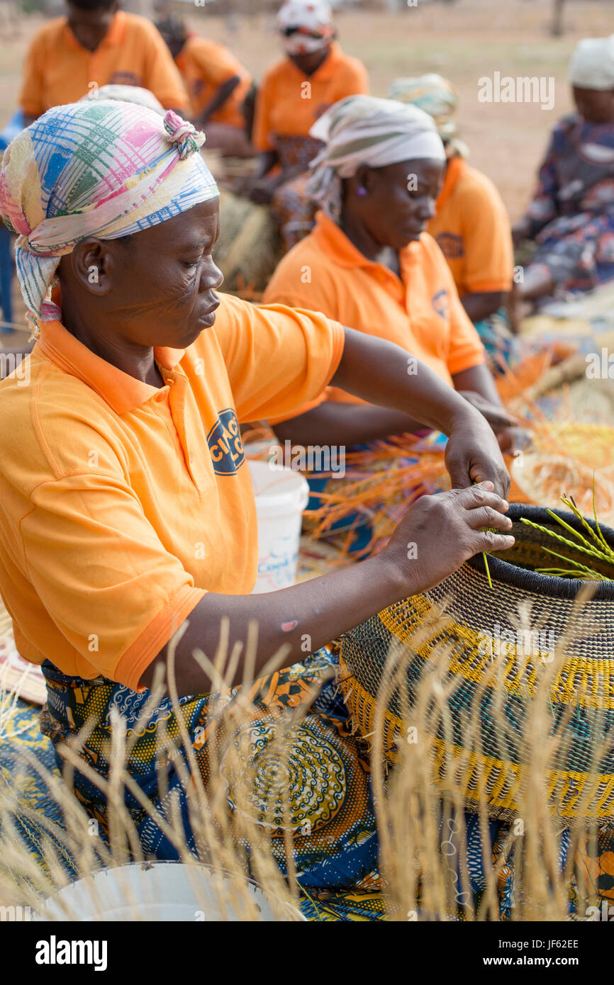 Women from a weaver’s cooperative weave traditional straw baskets