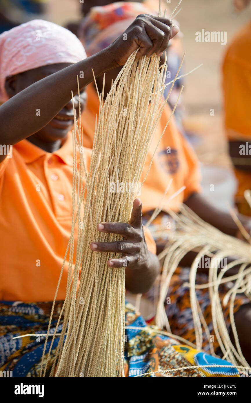 Women from a weaver’s cooperative weave traditional straw baskets