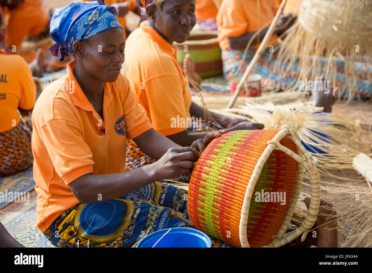 Women from a weaver’s cooperative weave traditional straw baskets