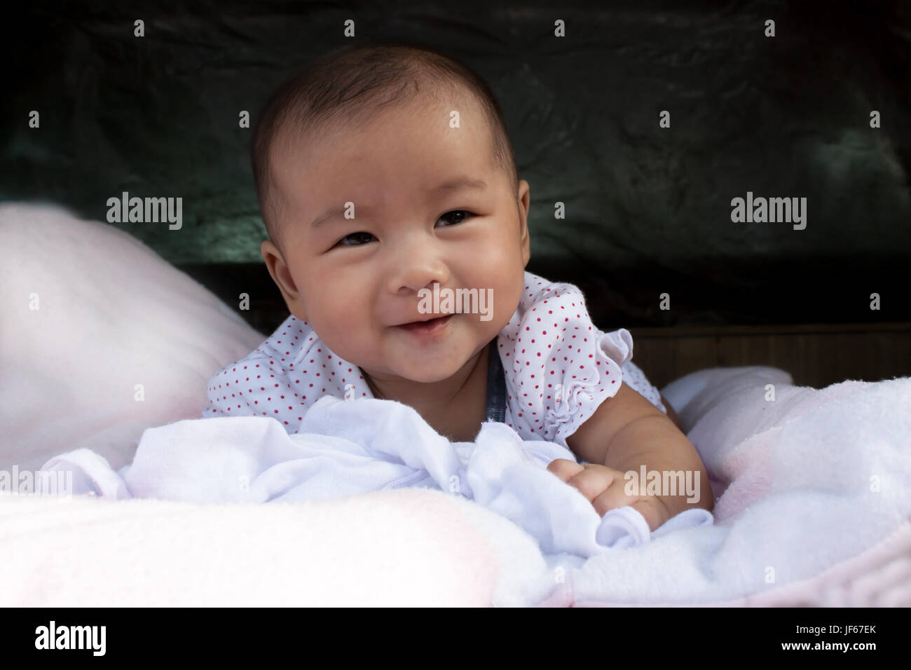 aisan baby lying on bed good emotion and healthy Stock Photo - Alamy