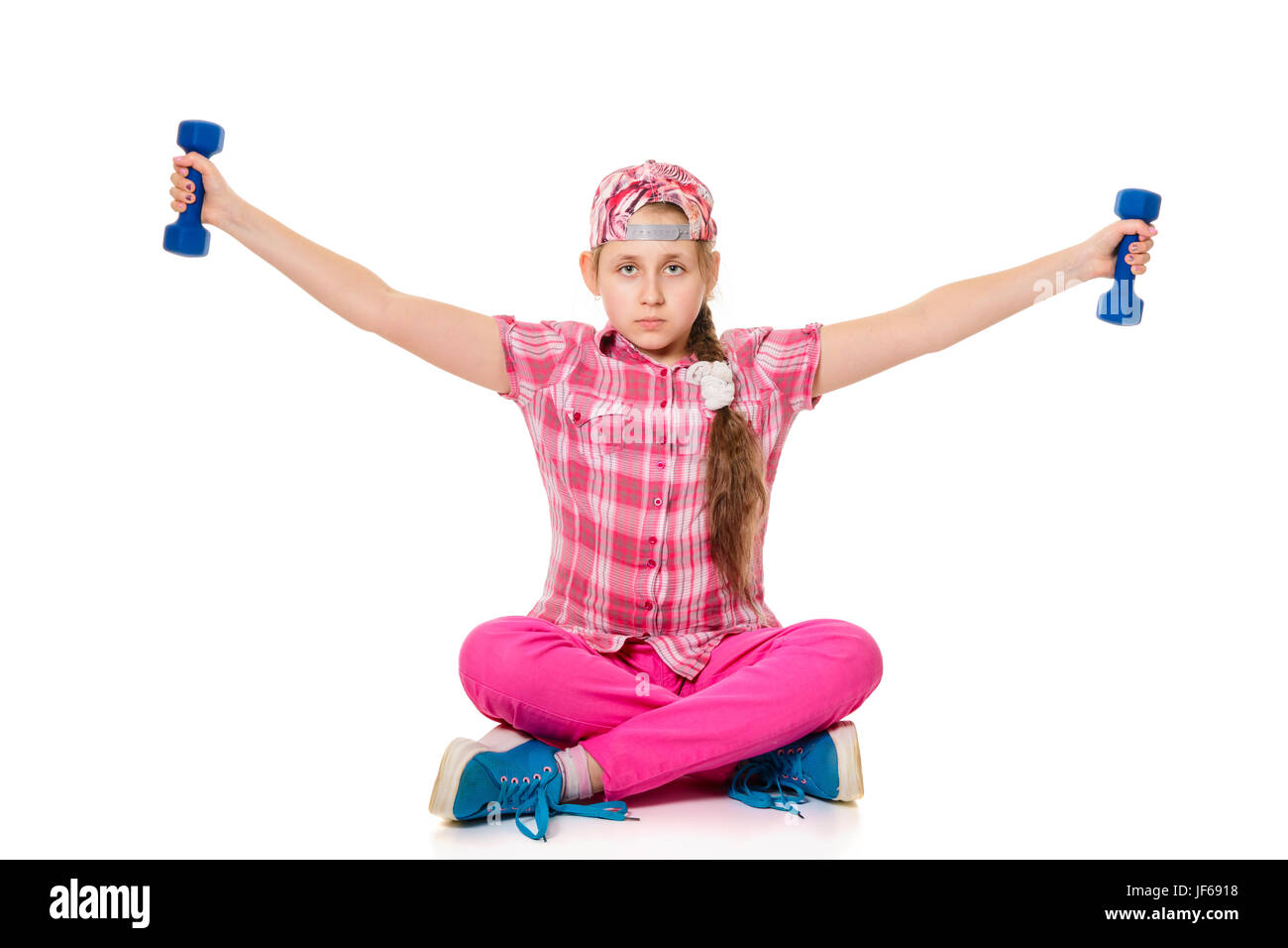 Girl is engaged with dumbbells, sitting on the floor. Isolated on white background Stock Photo