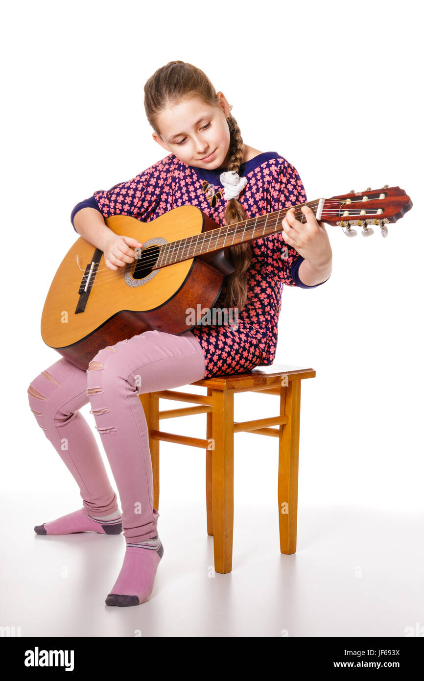 Girll teenager playing a guitar, isolated on a white background Stock