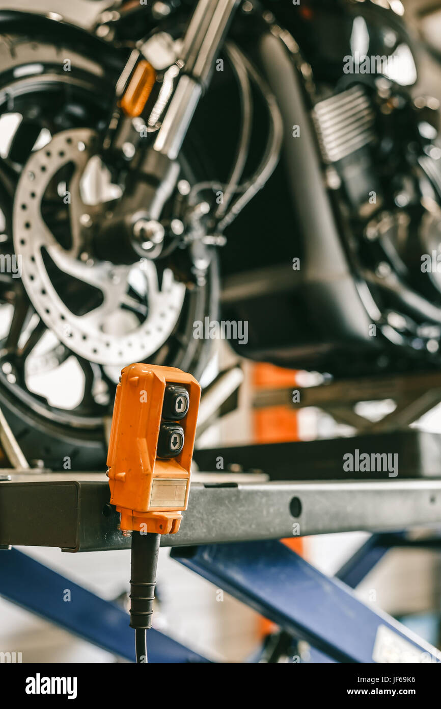 Closeup up down hydraulic controller switch on a lift with a motorcycle ...