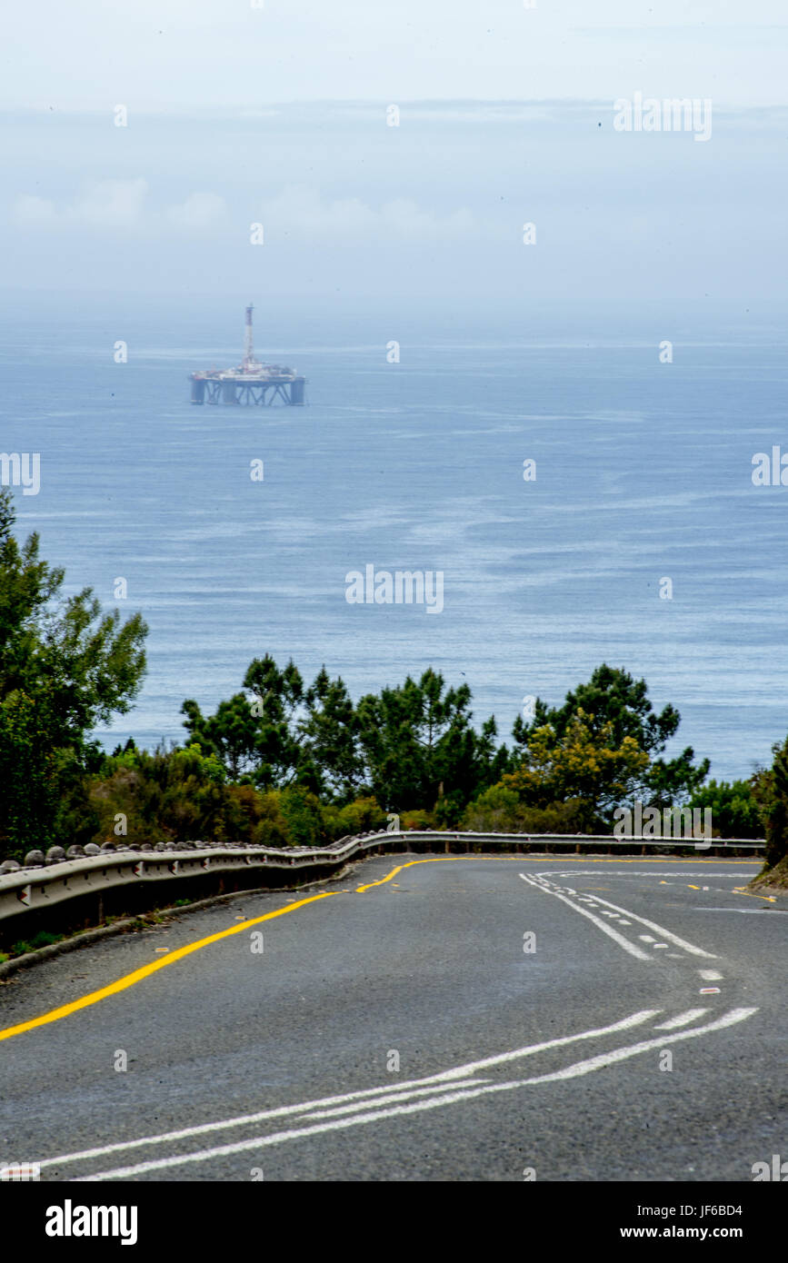 Open Road and Oil Drill Platform in Ocean Stock Photo