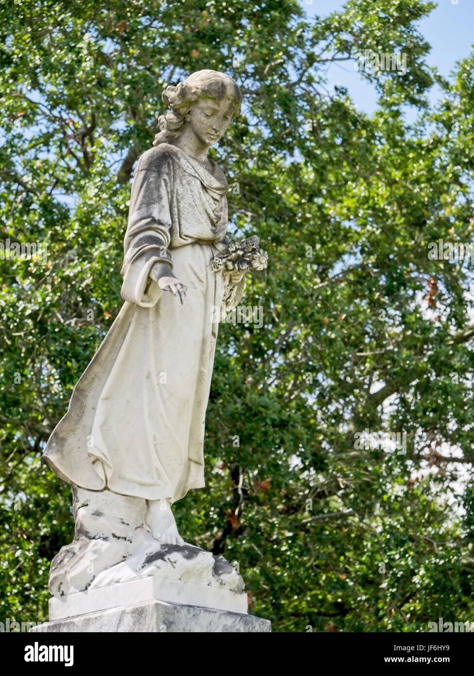New Orleans, LA USA - Jun 2, 2017  -  Statue of Woman with Flowers on Tomb Stock Photo