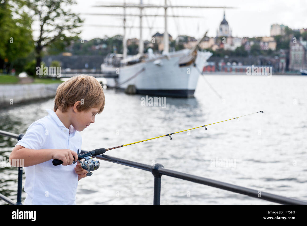 Boy fishing in city Stock Photo