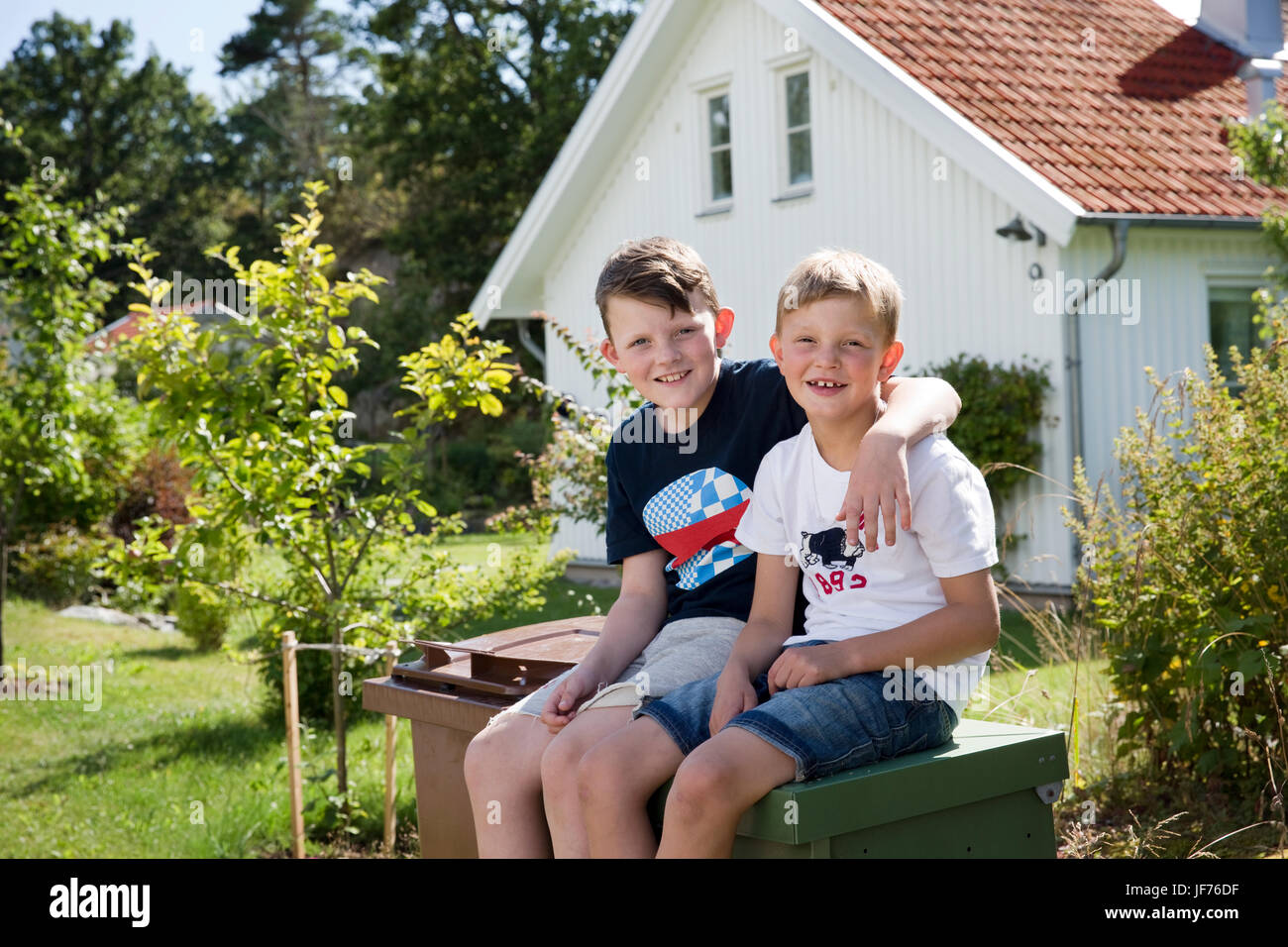 Two boys sitting outside Stock Photo - Alamy
