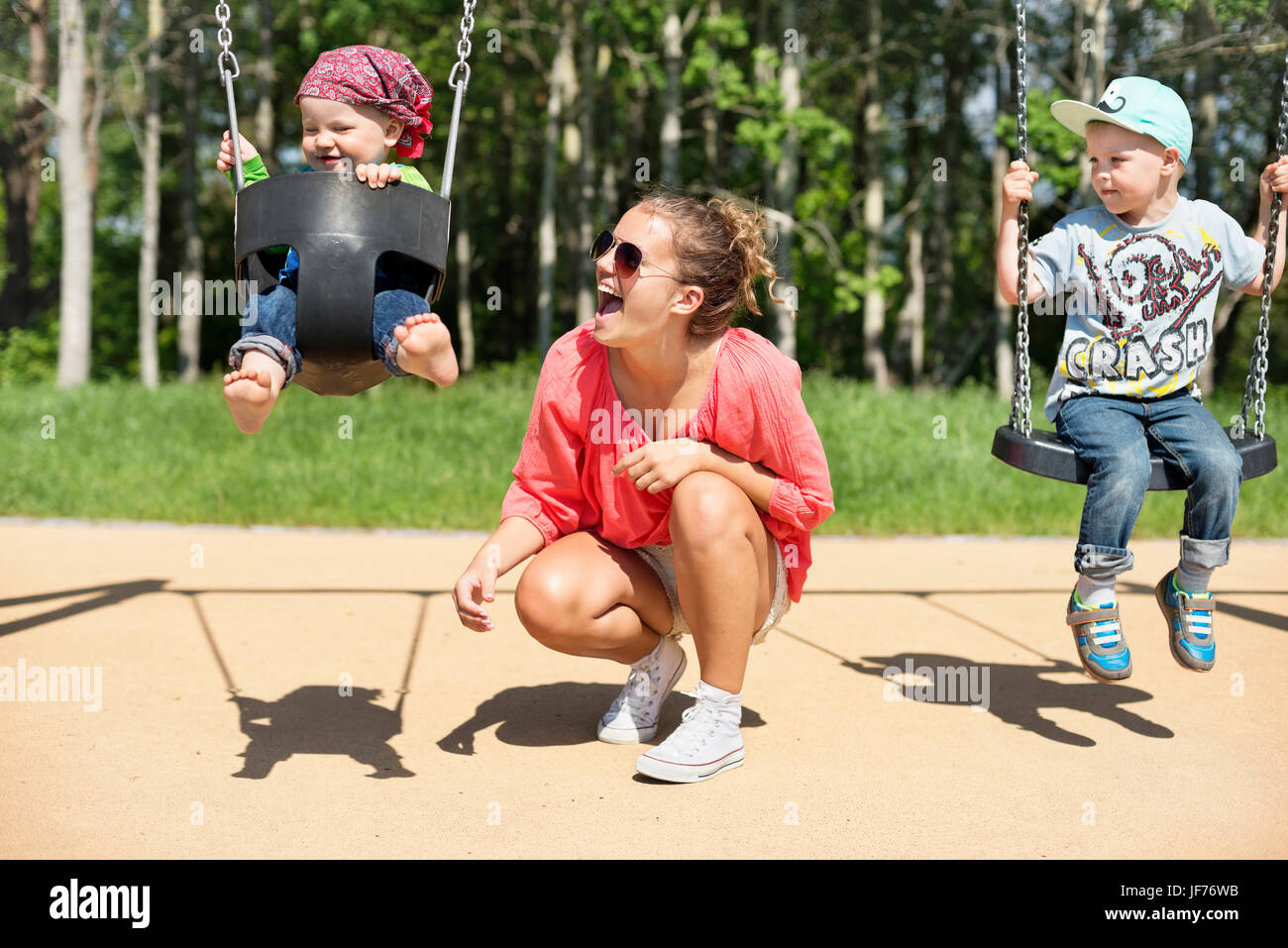 Mother swinging baby on playground Stock Photo Alamy
