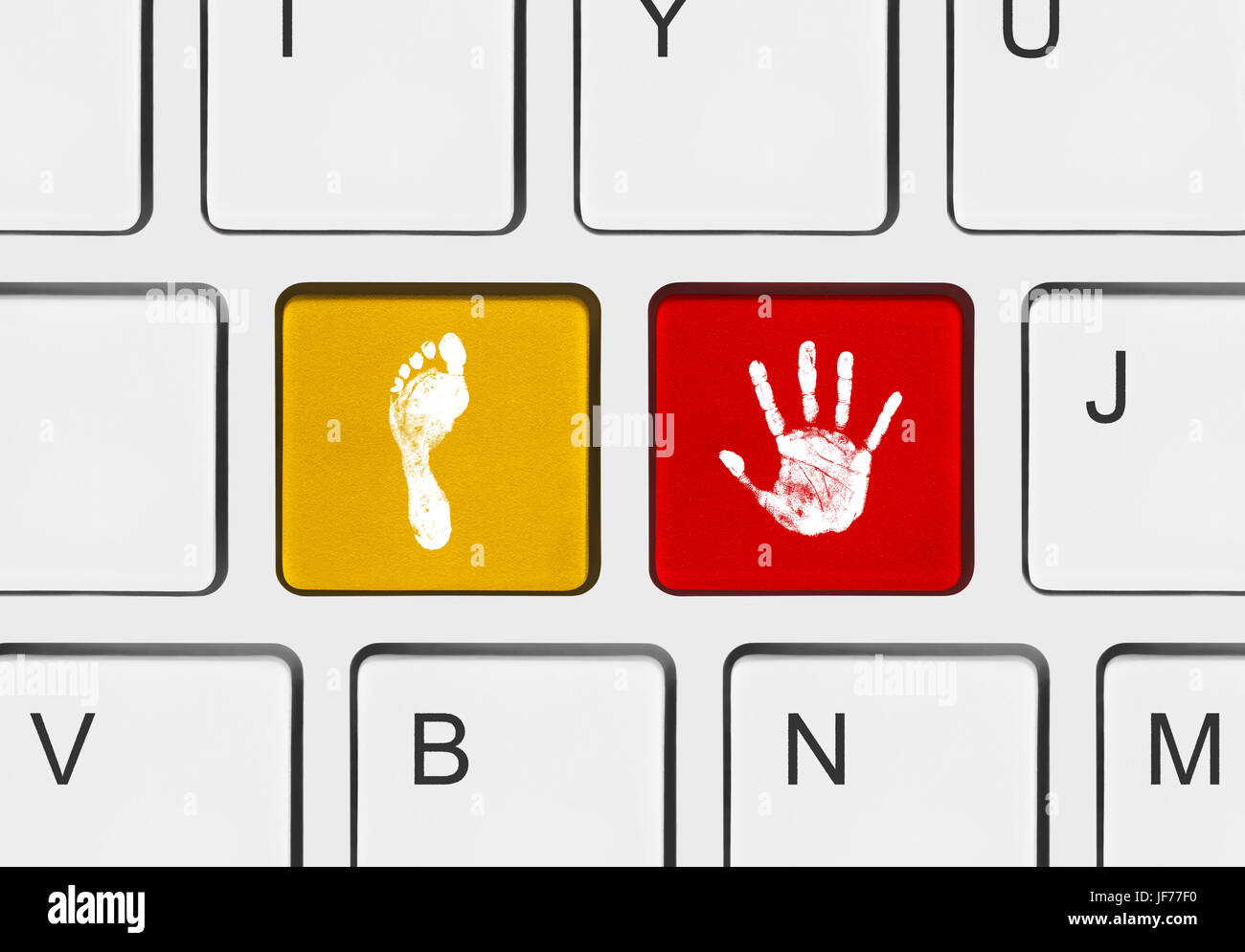 Printout of hand and foot on computer keys Stock Photo Alamy