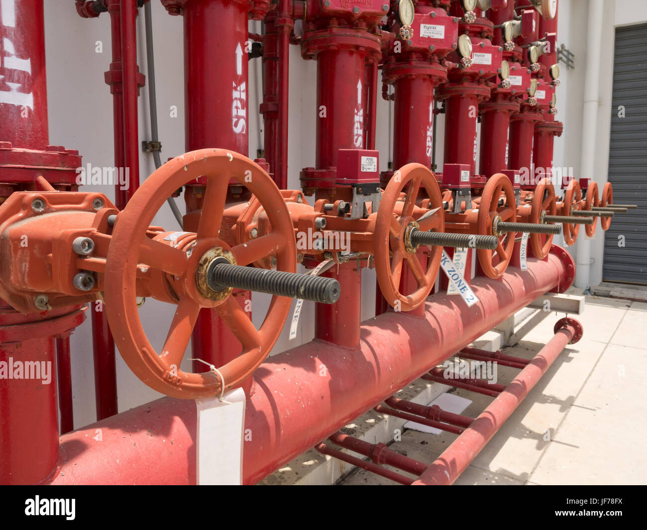 A row of red color fire fighting water supply pipeline system. Stock Photo