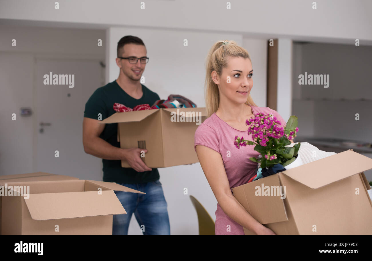 Happy young couple unpacking or packing boxes and moving into a new ...