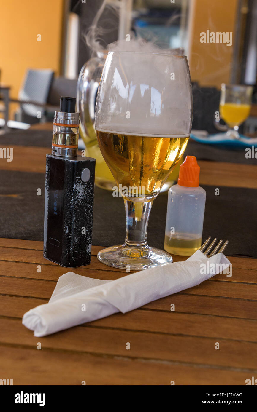 Vaporizer and smoking beer with bottle and fork on table Stock Photo