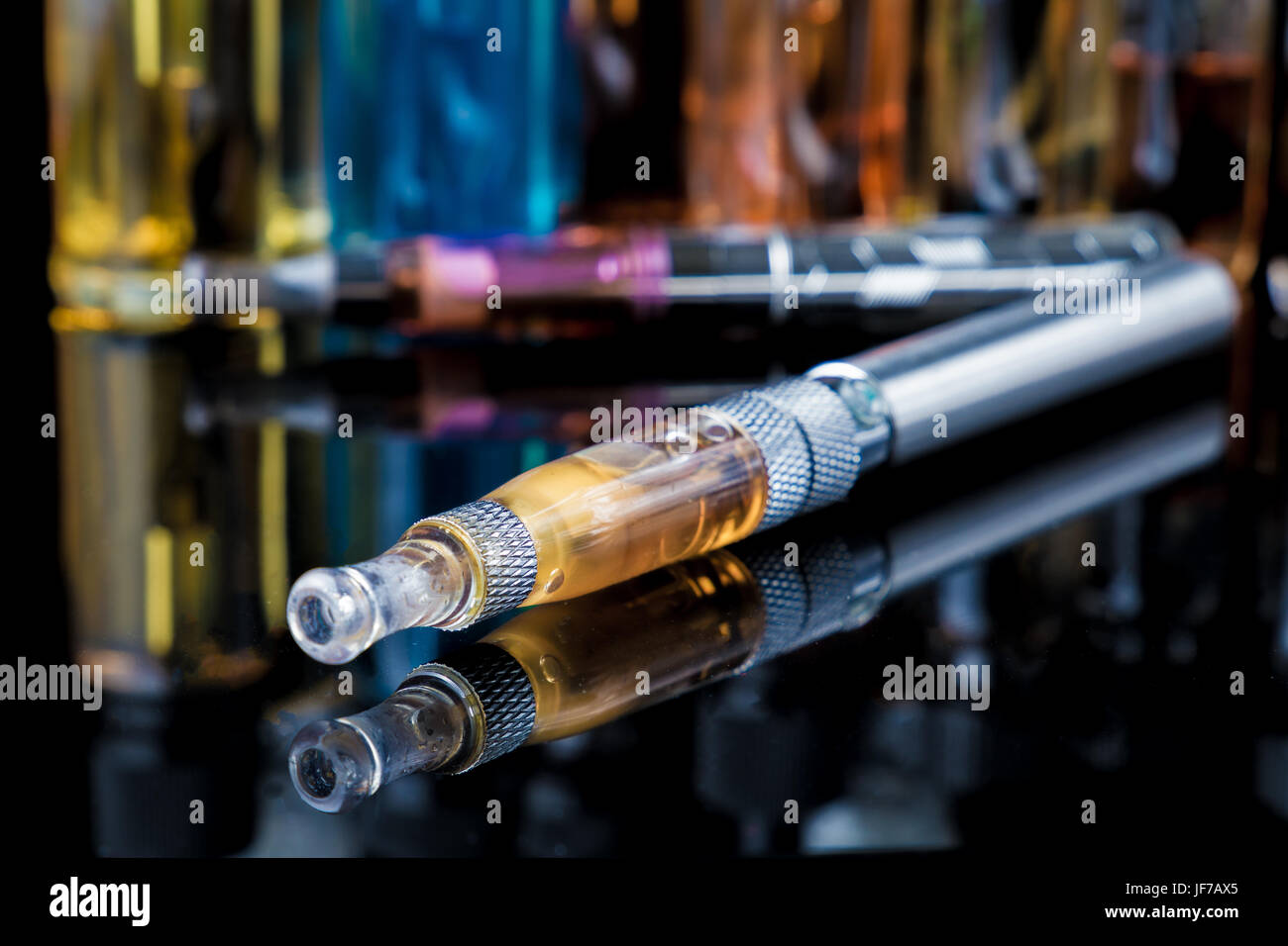 Electronic cigarette with e-liquid bottles in background Stock Photo