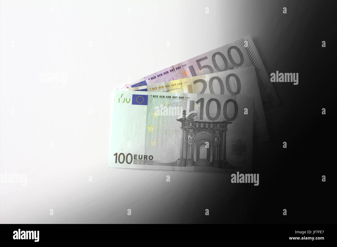 Euro banknotes disappearing into black, dirty earnings concept, copy space Stock Photo