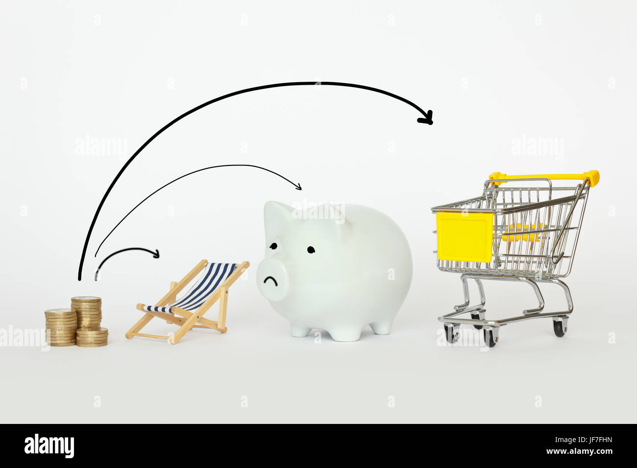 A stack of coins with a deck chair, piggy bank and a shopping trolley with 3 arrows, symbolic for distributing income, earnings or revenue money for h Stock Photo