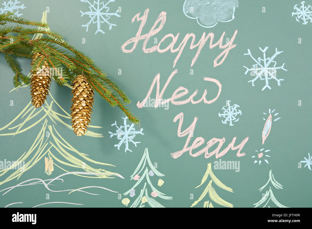 Christmas decoration from branch of spruce with golden cones on background of blackboard with title HAPPY NEW YEAR Stock Photo